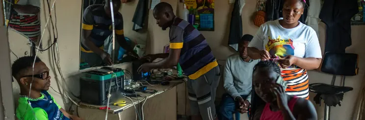 Customers charging devices from a battery in a South African salon